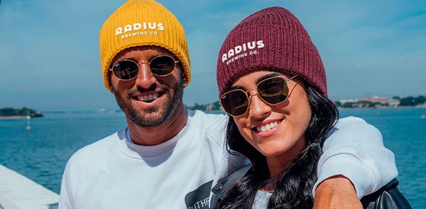 A man and woman are wearing beanies.